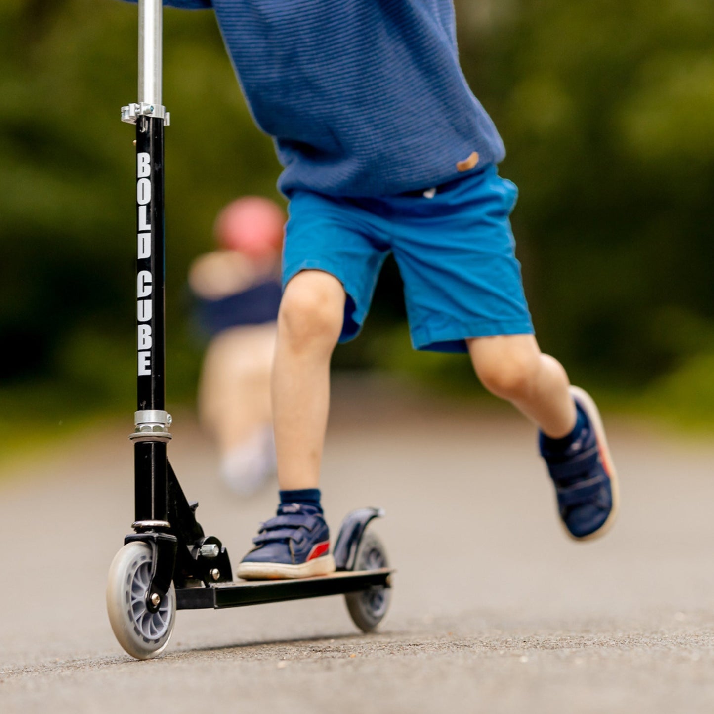 Child riding a scooter with 'Bolt Cube' branding on a blurred background