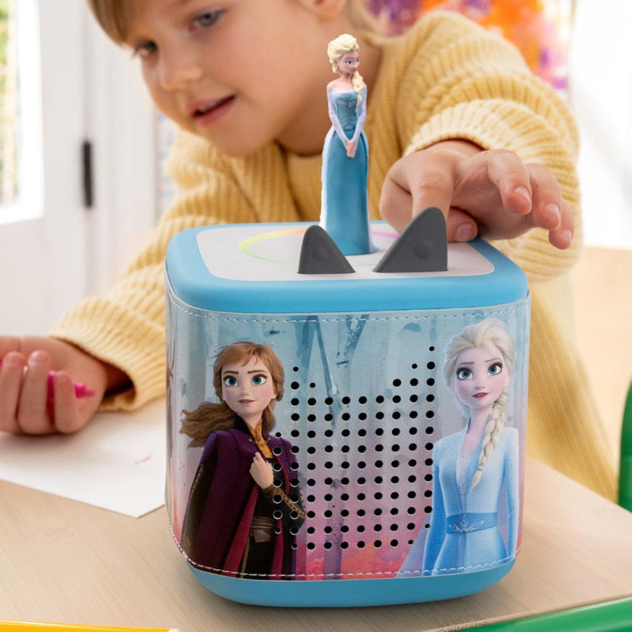 Child playing with a toy pencil sharpener featuring characters from Frozen.
