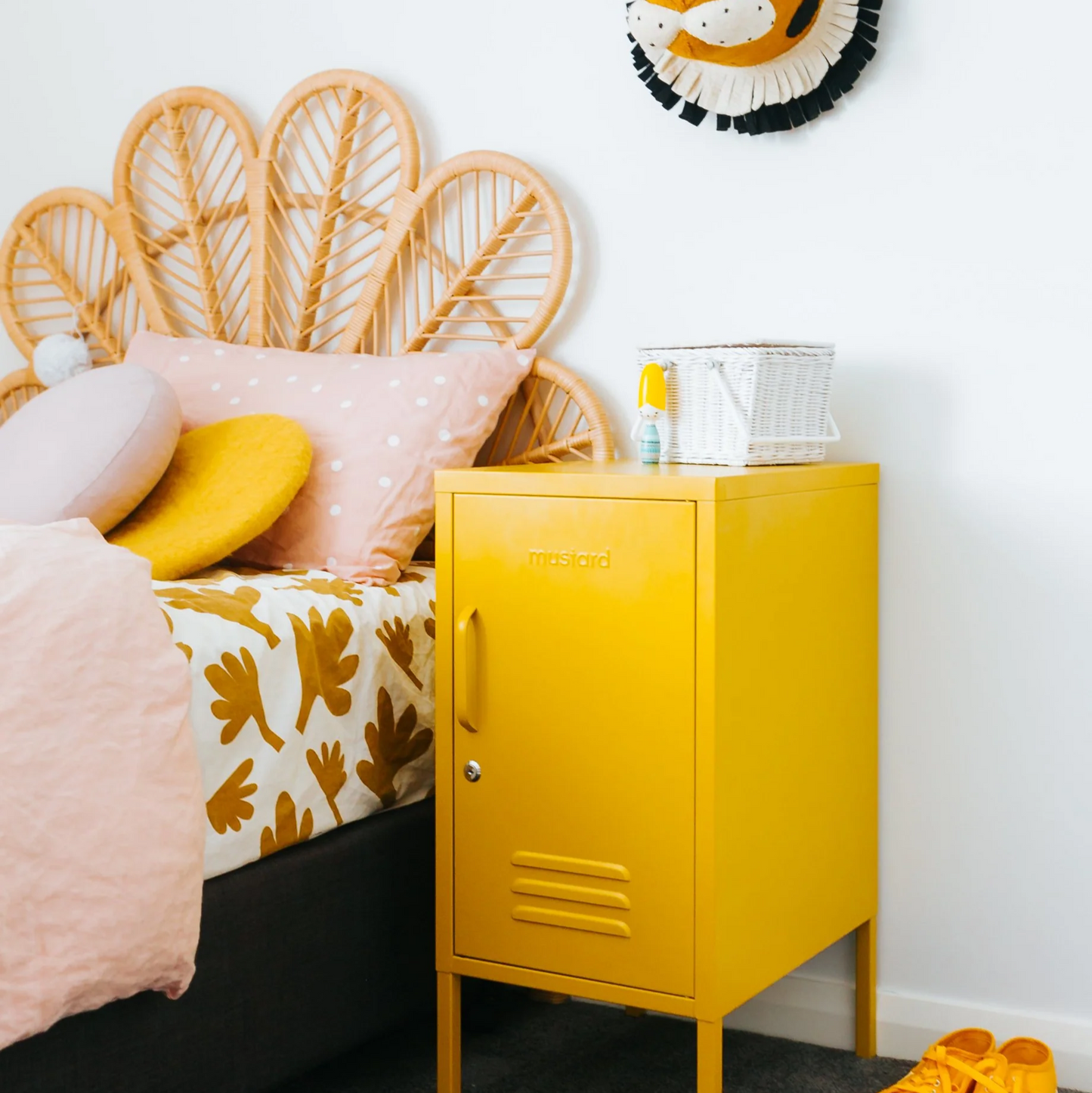 Yellow locker-style nightstand next to a bed with a rattan headboard and tiger decor on the wall.