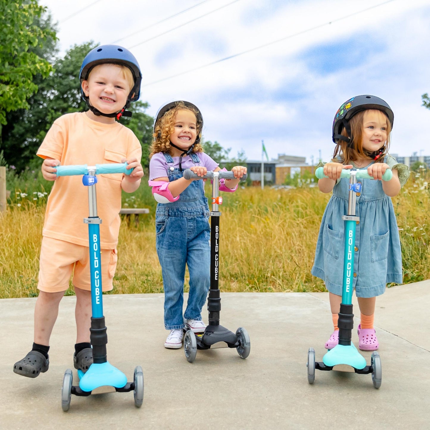 Three children on scooters in a park setting