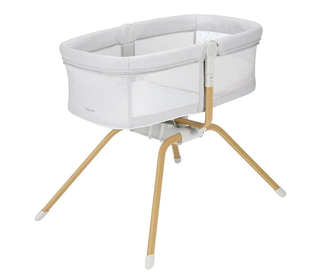 White baby bassinet with wooden legs on a white background