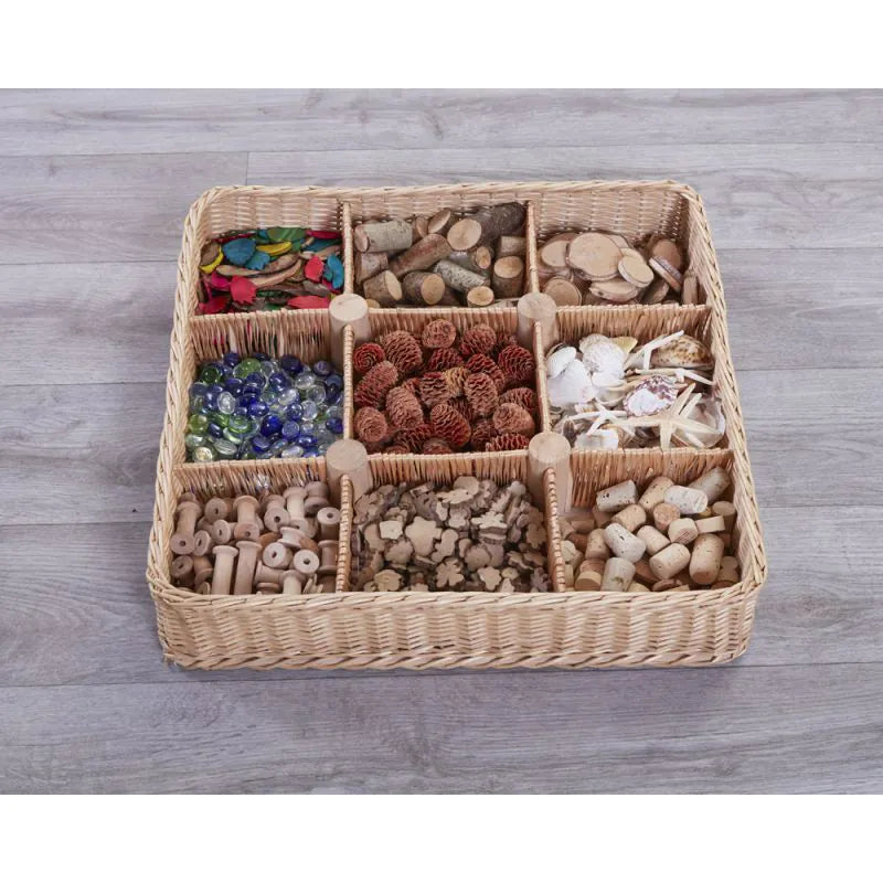 Woven storage basket with compartments filled with various small items on a wooden surface