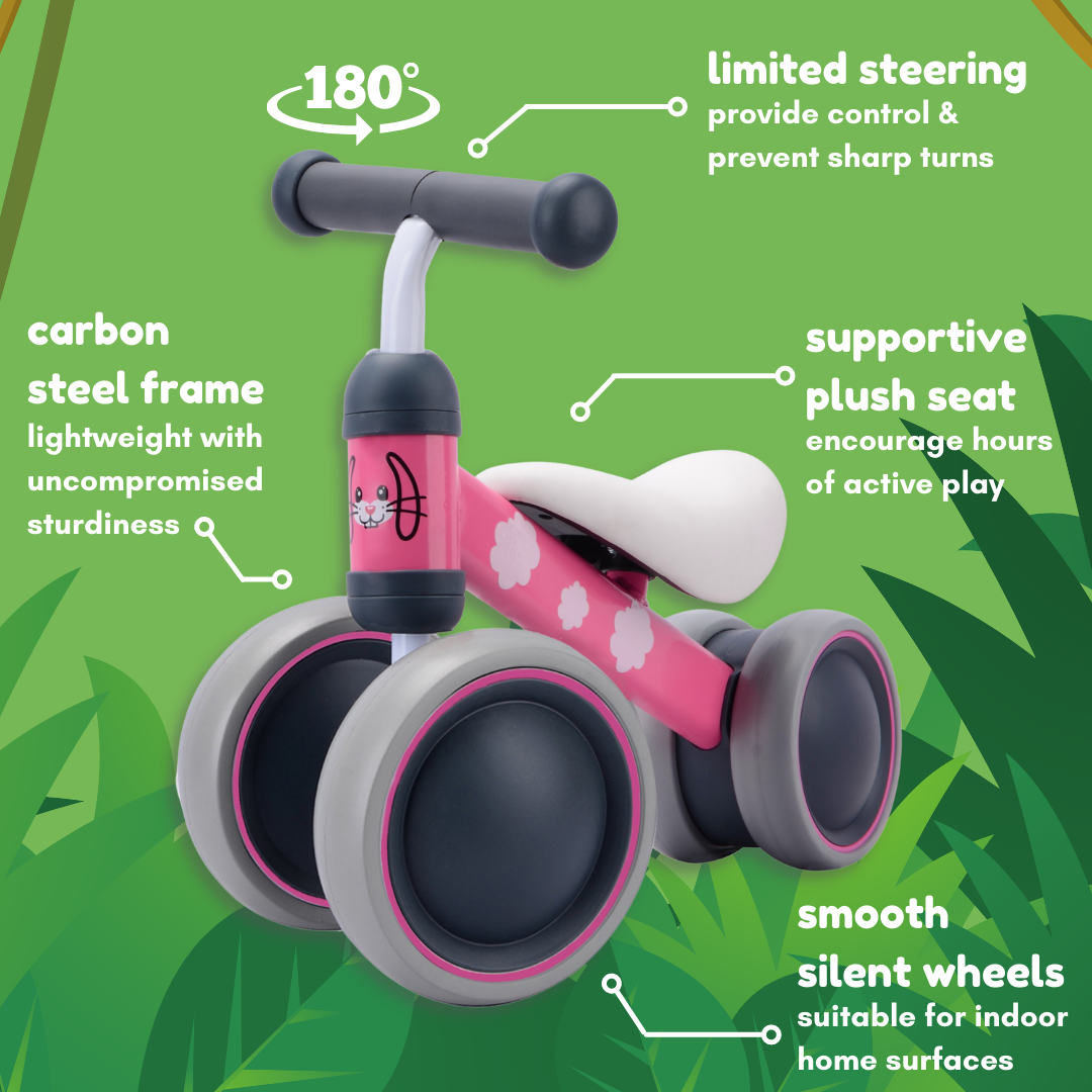 Pink balance bike with features highlighted on a green background