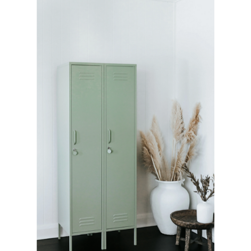 Green metal locker against a white wall with decorative plants.