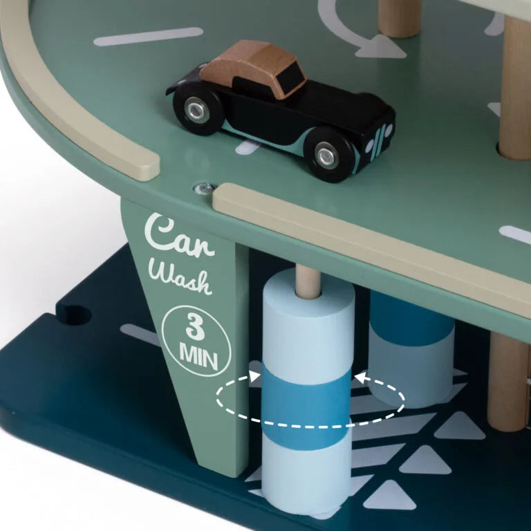 Wooden toy car wash set with a toy car on a green platform.