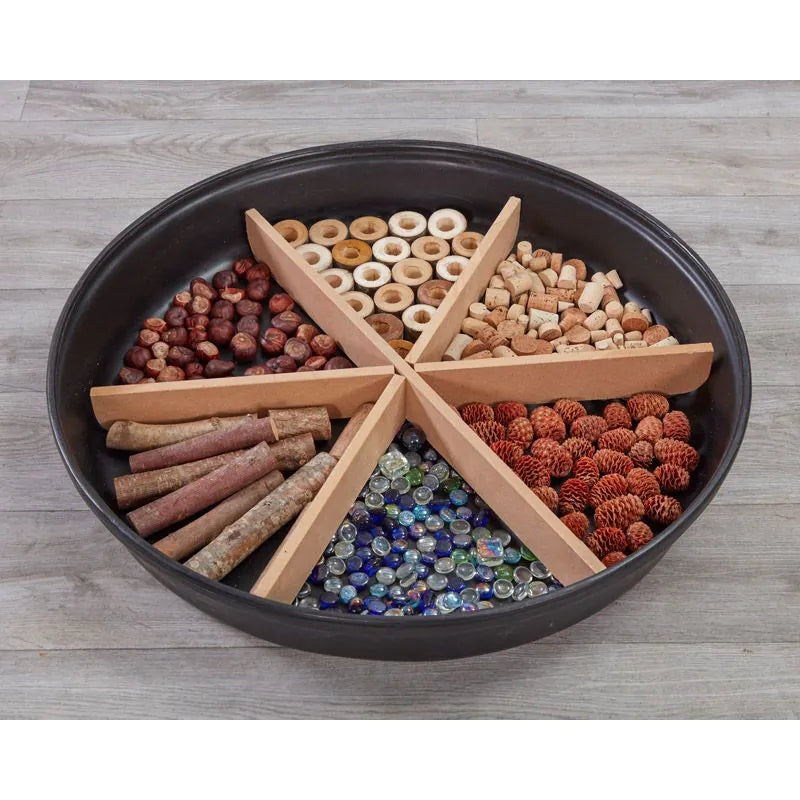 Black tray with compartments containing various pet treats on a wooden floor.
