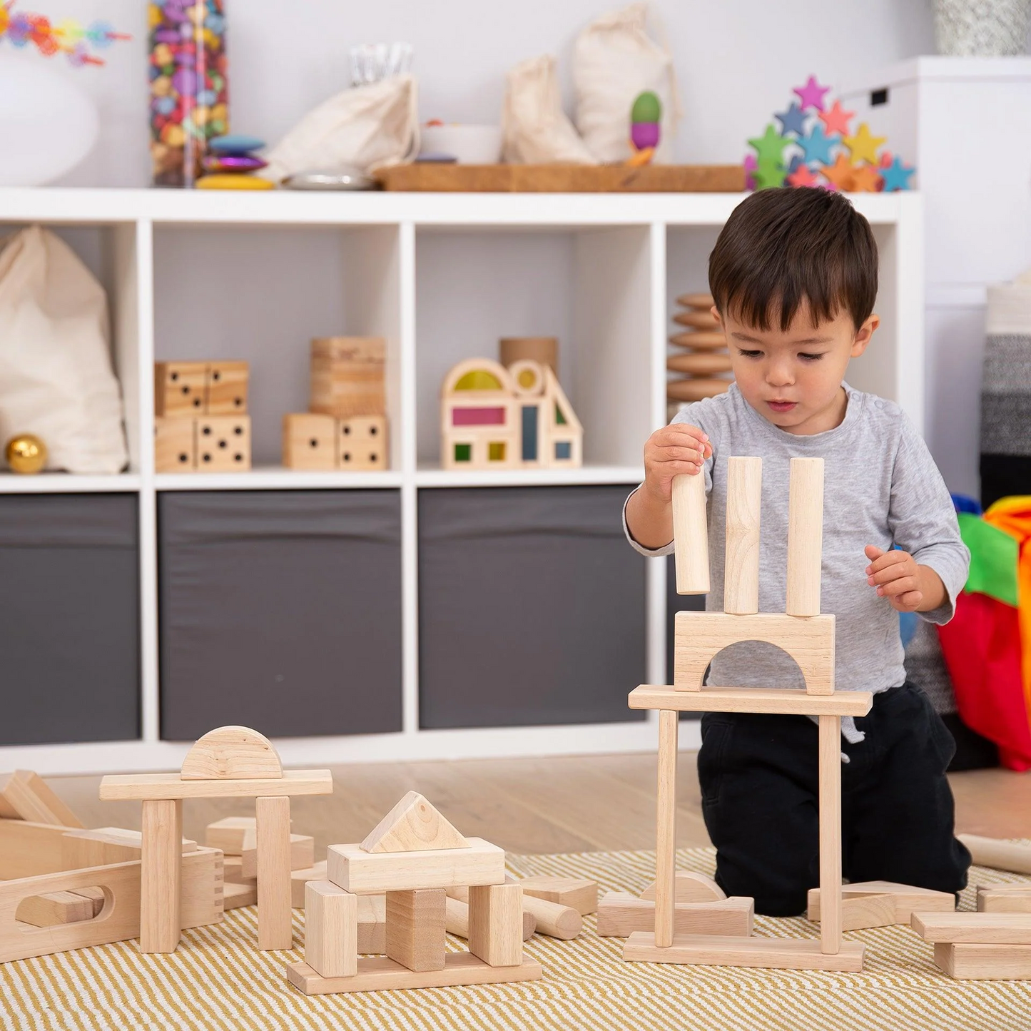 Child playing with wooden building blocks in a classroom setting