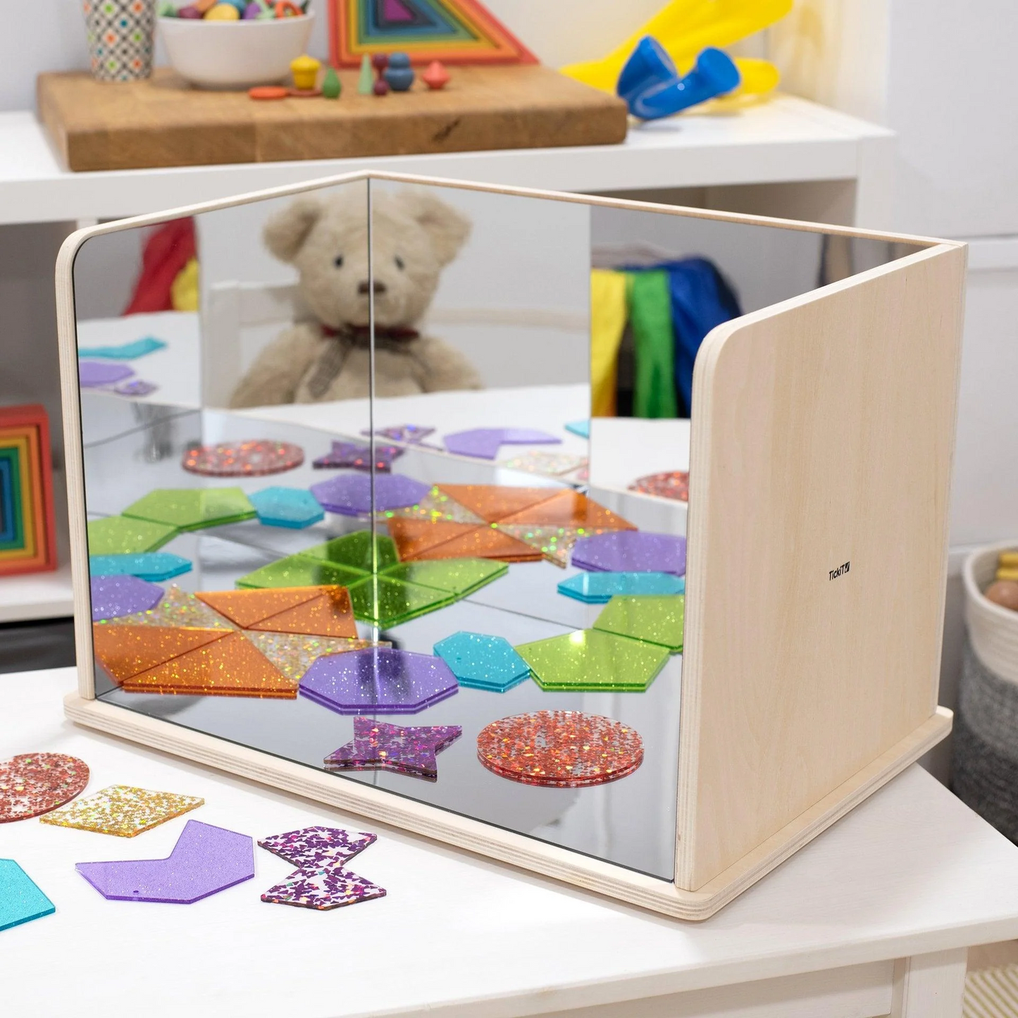 Colourful sensory shapes set up on the mirror set reflecting the shapes in the mirrors