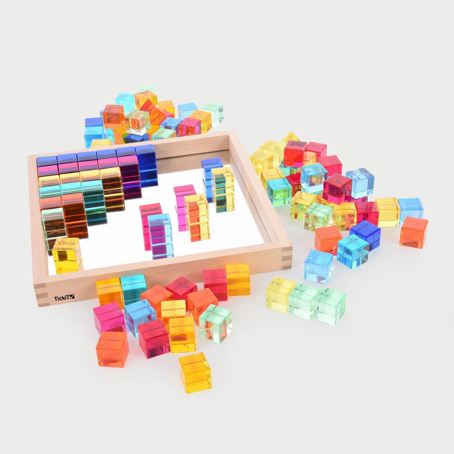 Acrylic cubes in a tray and surrounding the wooden tray.