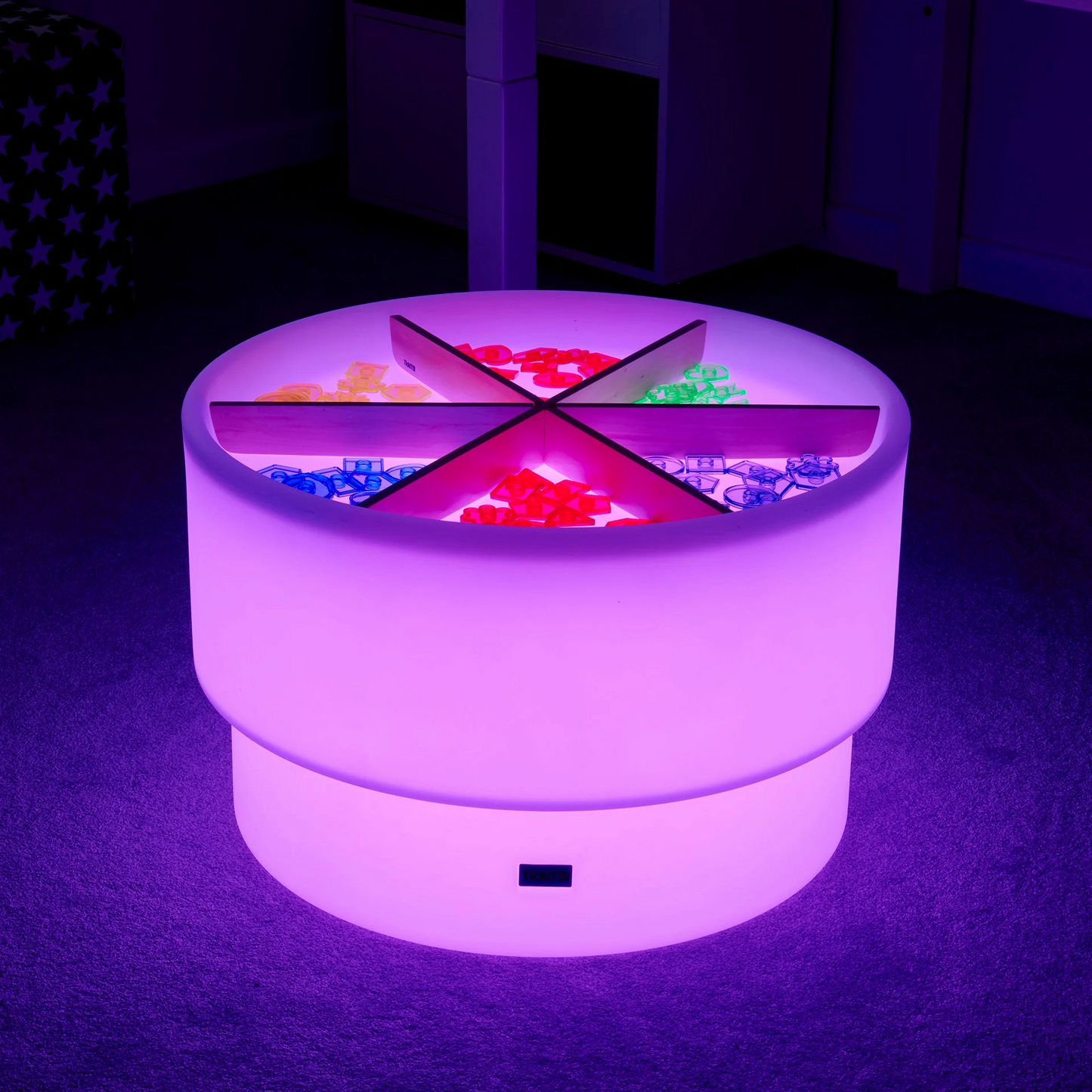 Dsicovery sensory table with loose parts glowing purple
