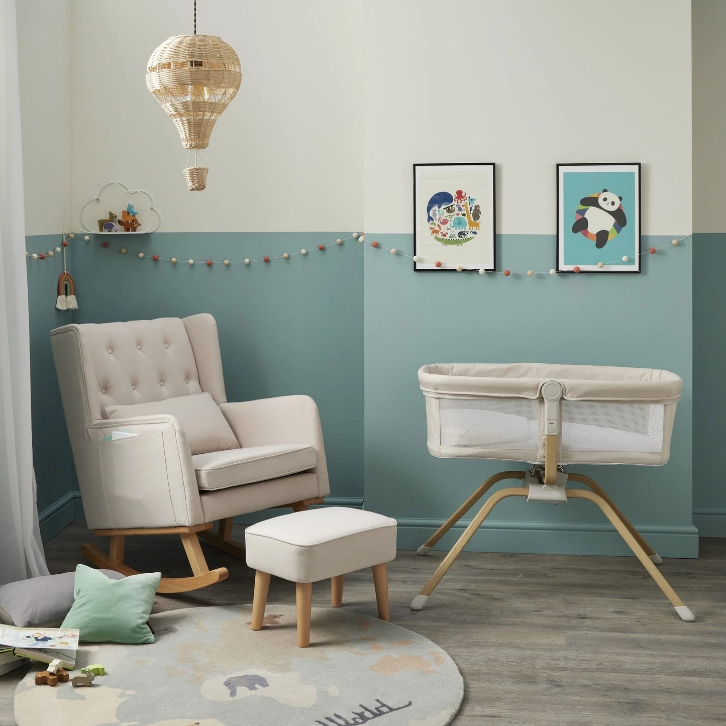 Nursery room with rocking chair, ottoman, and crib against a light blue wall.