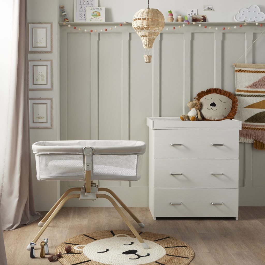 Nursery room with crib, dresser, and decorative items.