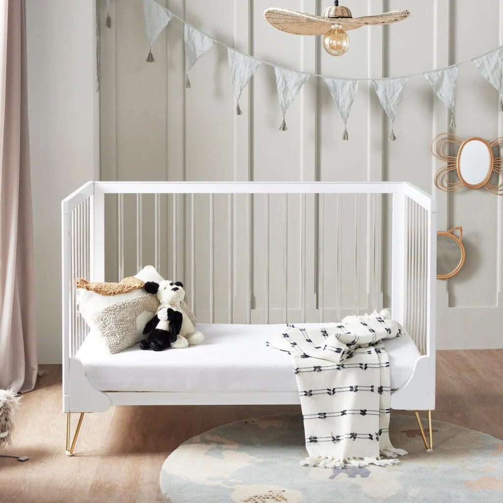 White crib with decorative items in a nursery setting
