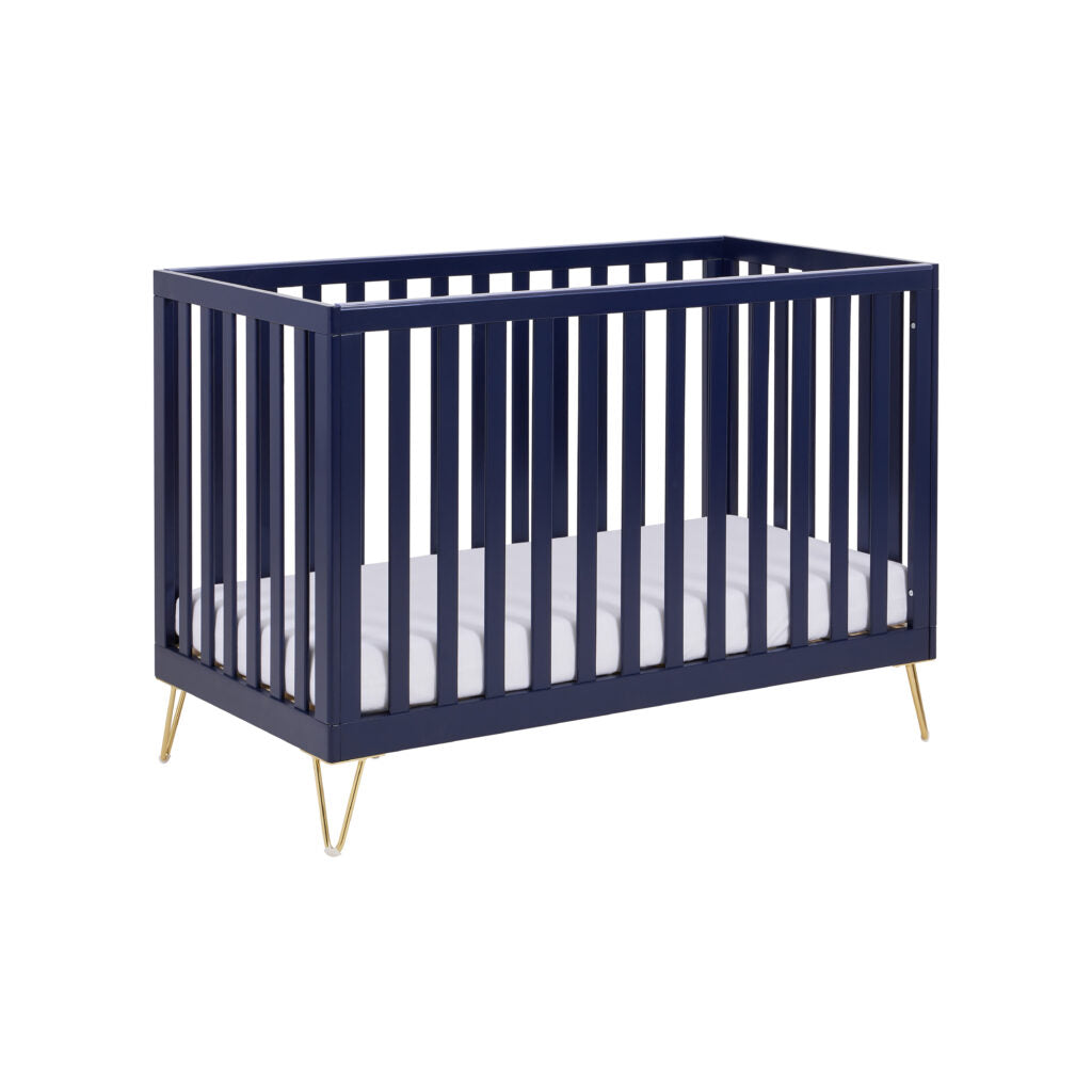 Navy crib with white mattress on a white background