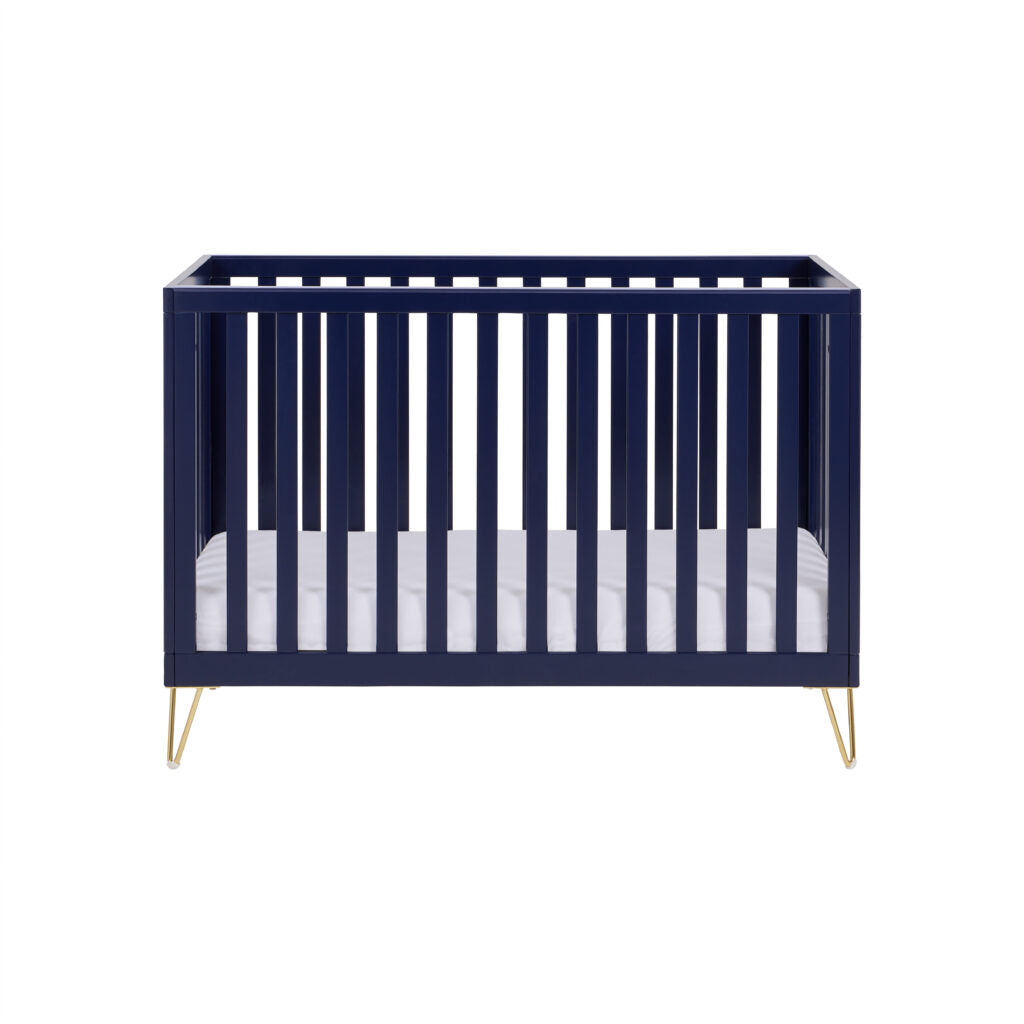 Navy crib with white mattress on a white background