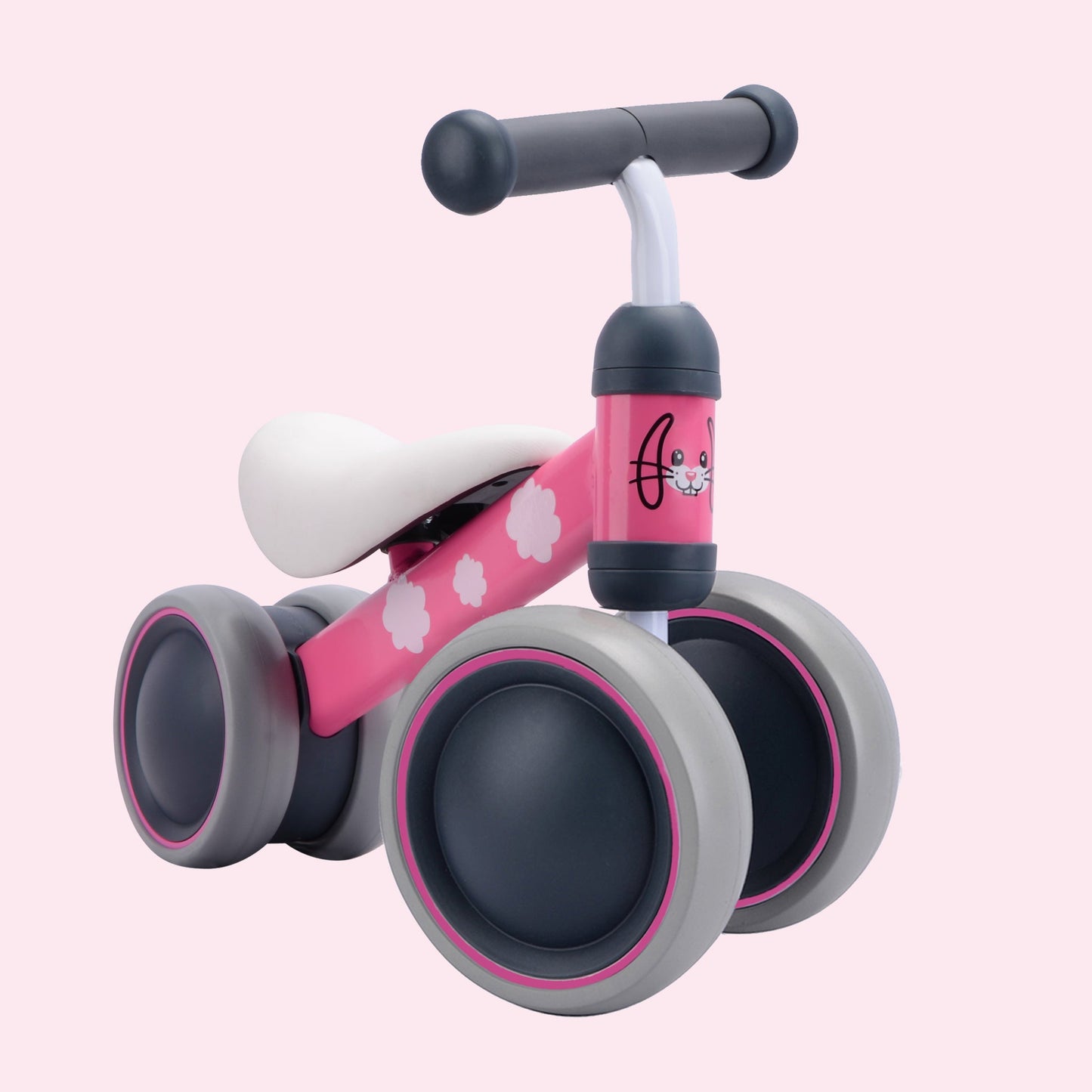 Pink balance bike with gray wheels on a pink background