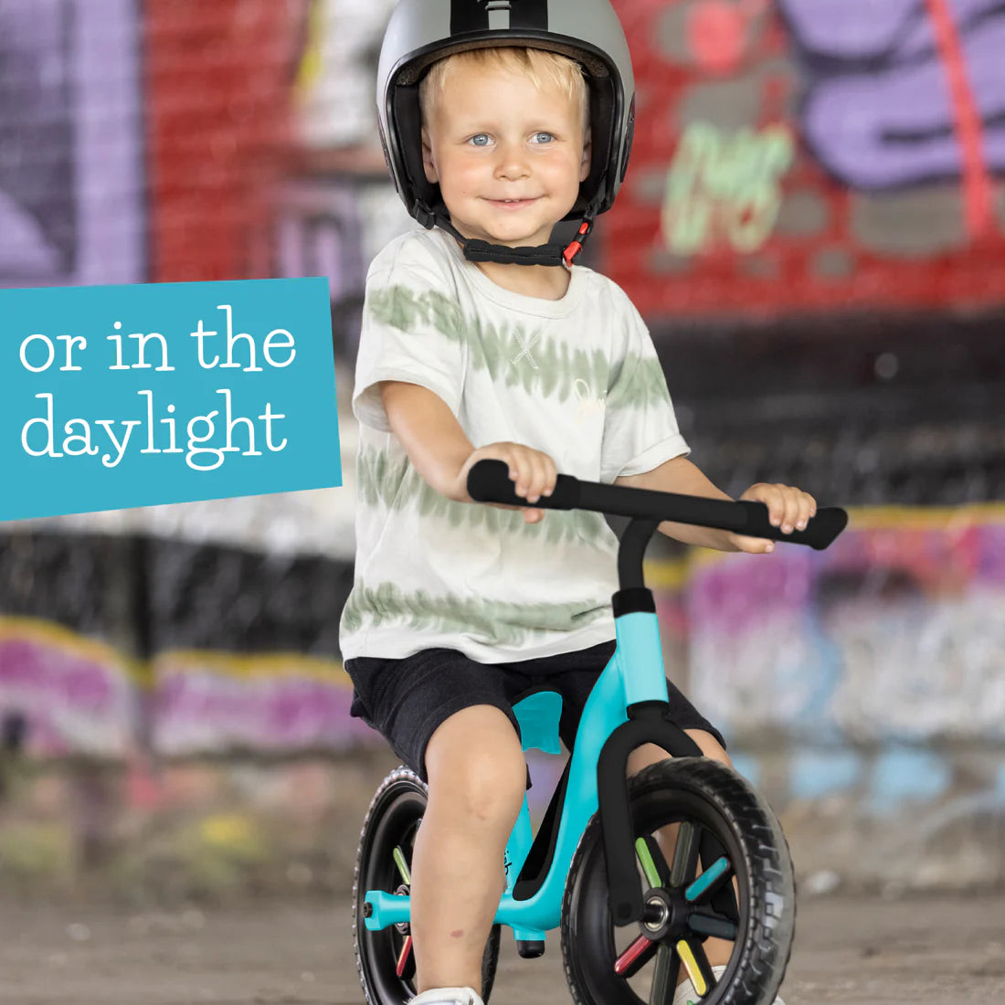 Child riding a balance bike with a helmet on a colorful street background