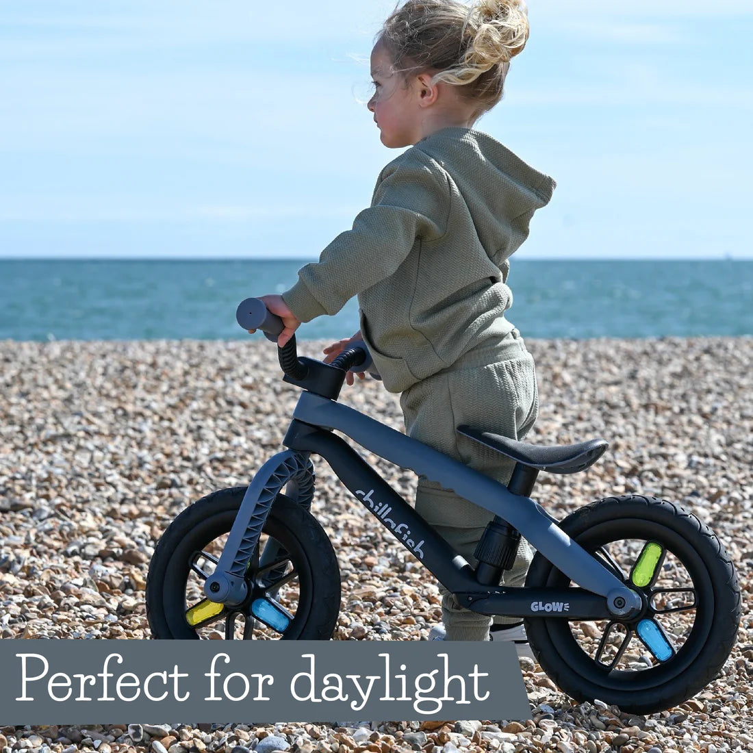 Child on a balance bike at the beach with text 'Perfect for daylight'.