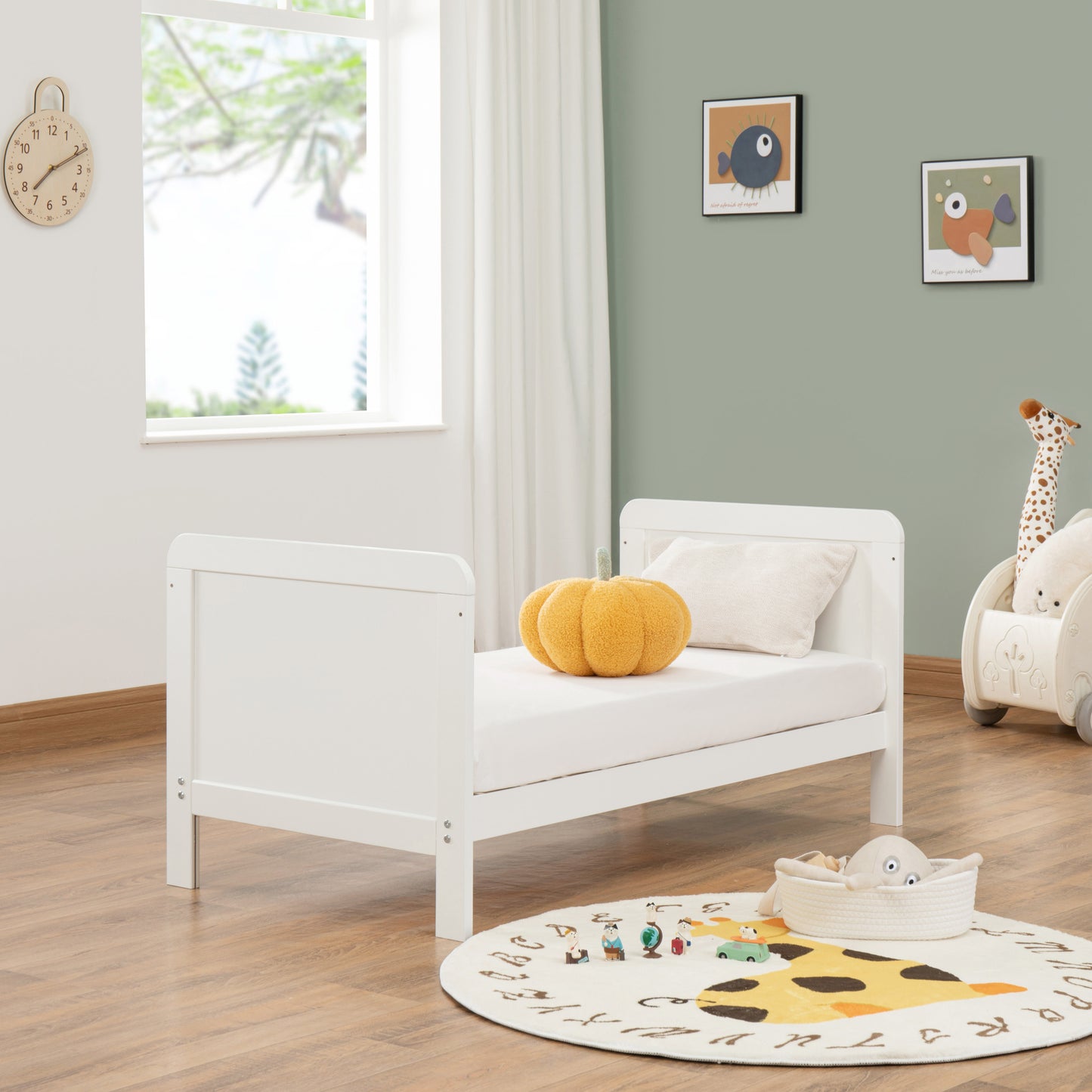 White children's bed in a room with toys and decor