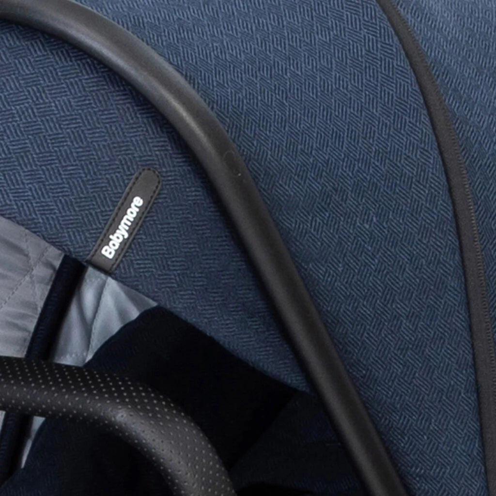 Close-up of a blue textured fabric with black piping and a visible brand label.
