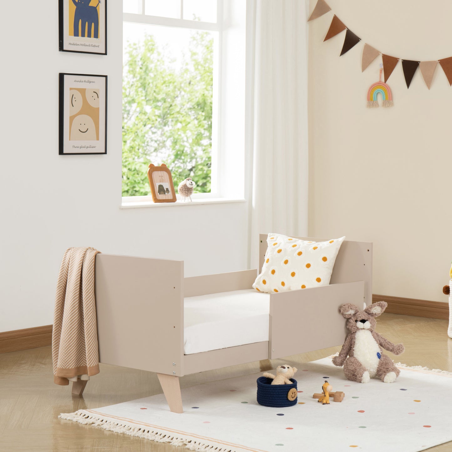 Children's room with a cot bed, toys, and decorative elements.