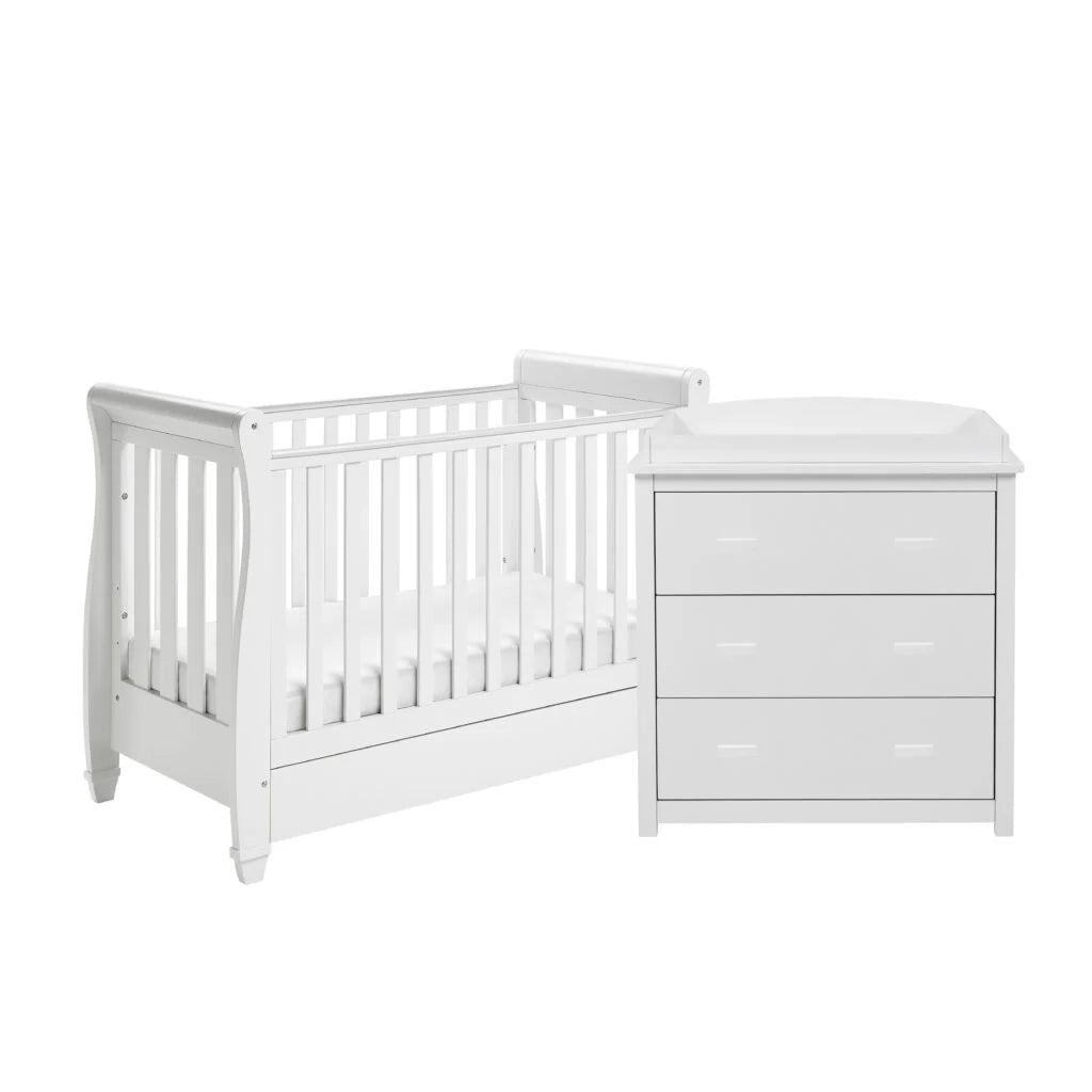 White crib and matching dresser on a white background