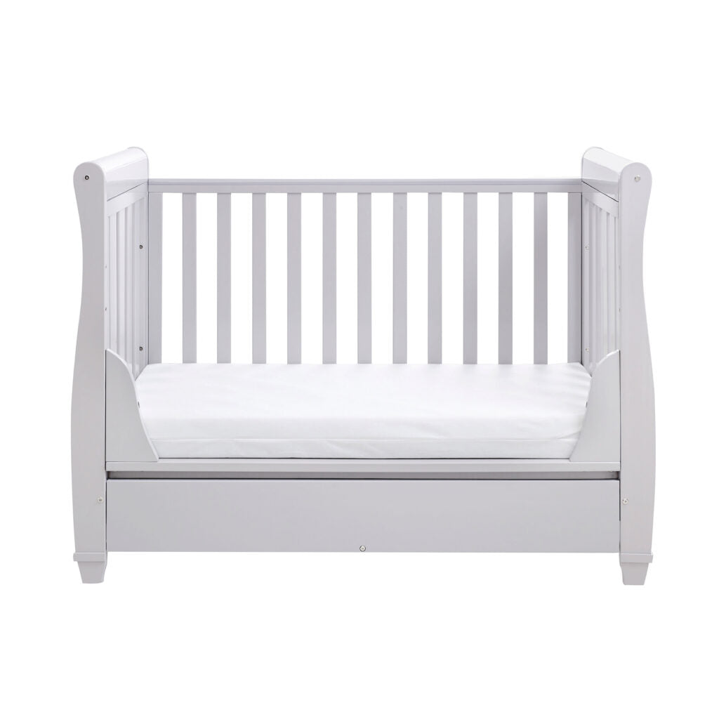 White crib with a white mattress on a white background
