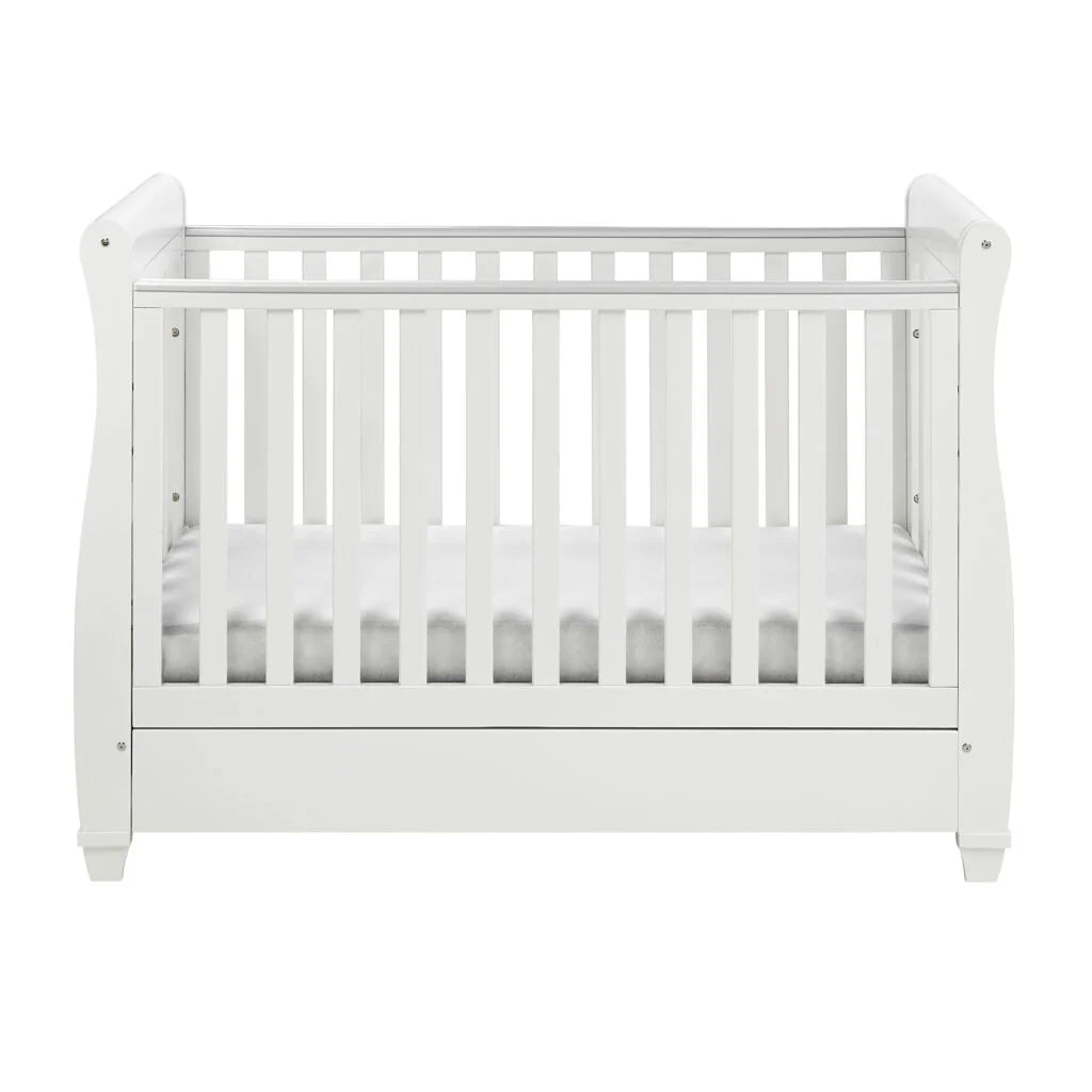 White crib with a white mattress on a white background