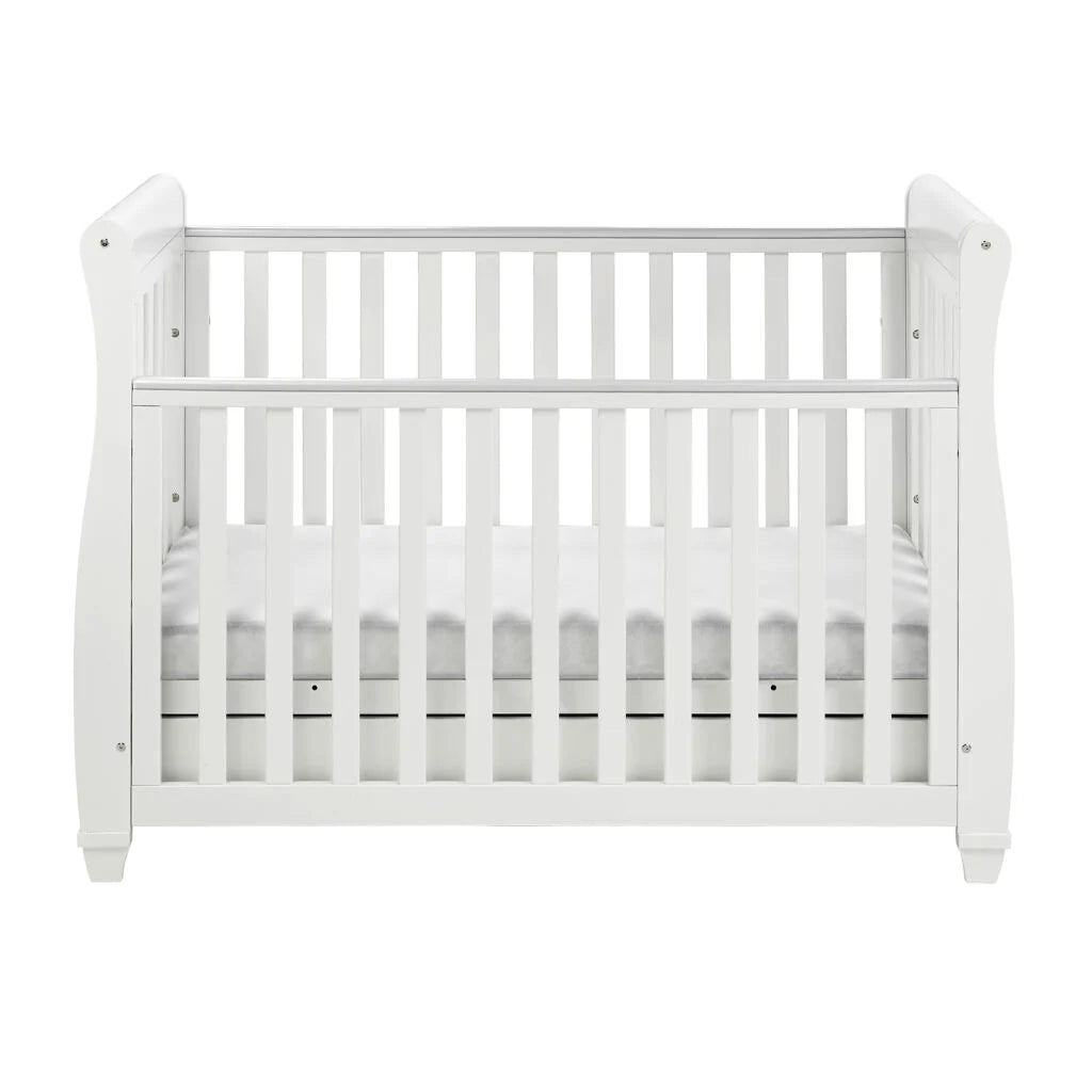 White crib with a white mattress on a white background