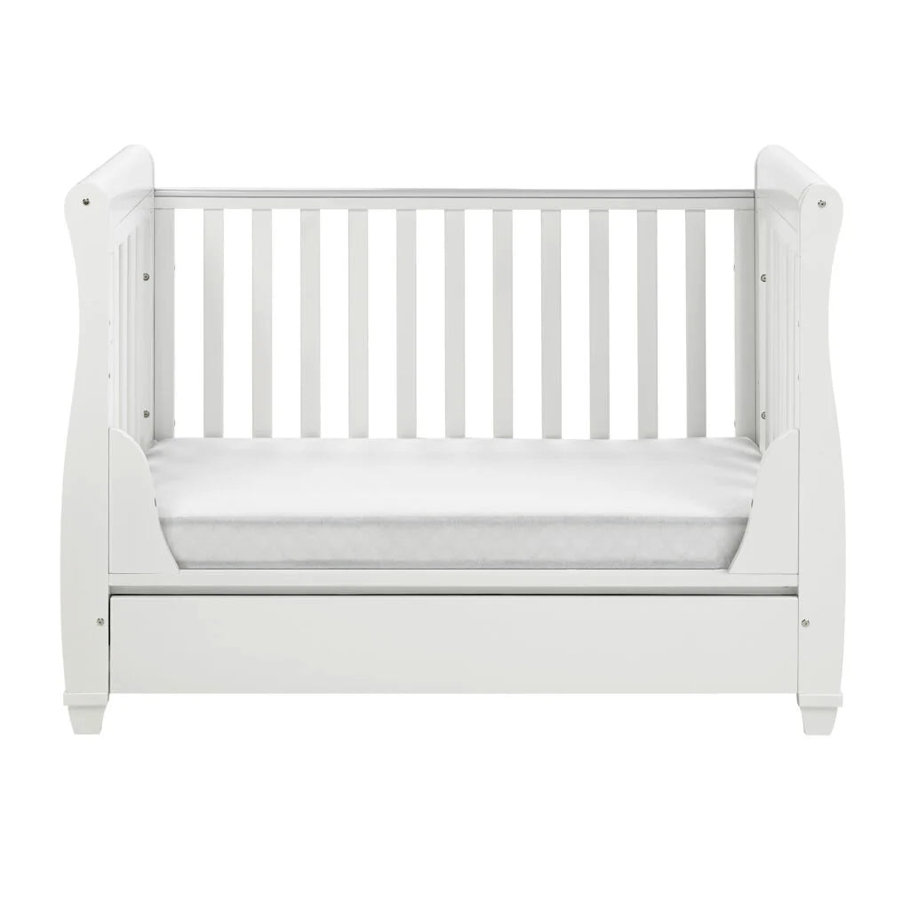 White crib with mattress on a white background