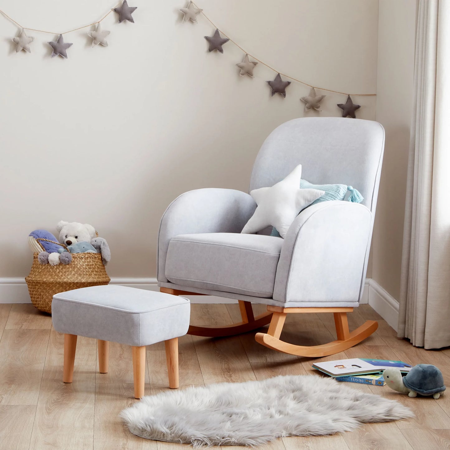 Gray rocking chair with ottoman in a nursery setting with toys and decorations.