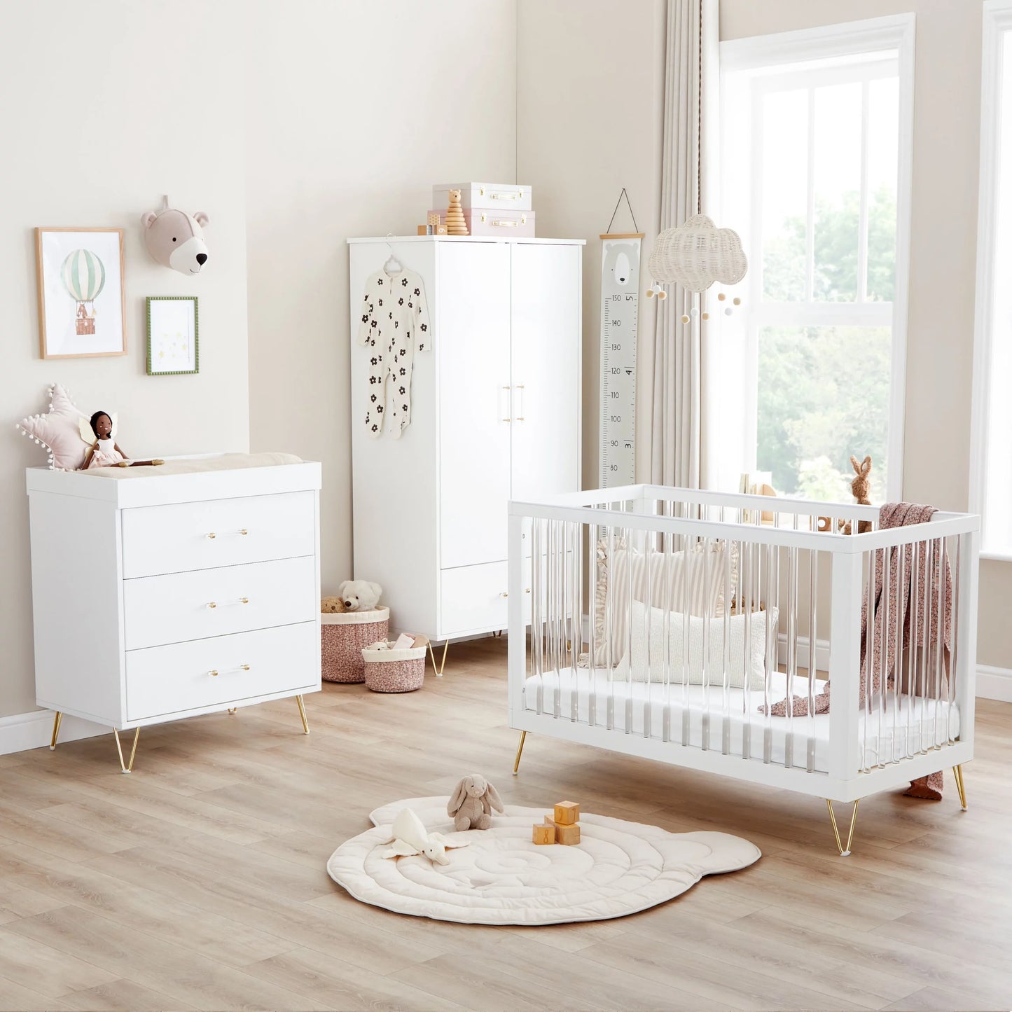 Nursery room with white crib, dresser, and wardrobe.