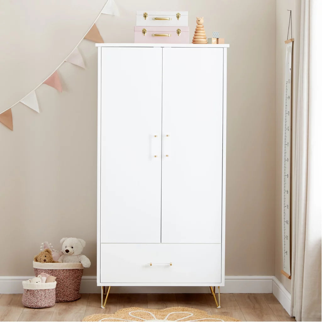 White wardrobe with gold legs in a child's room with toys and decor.