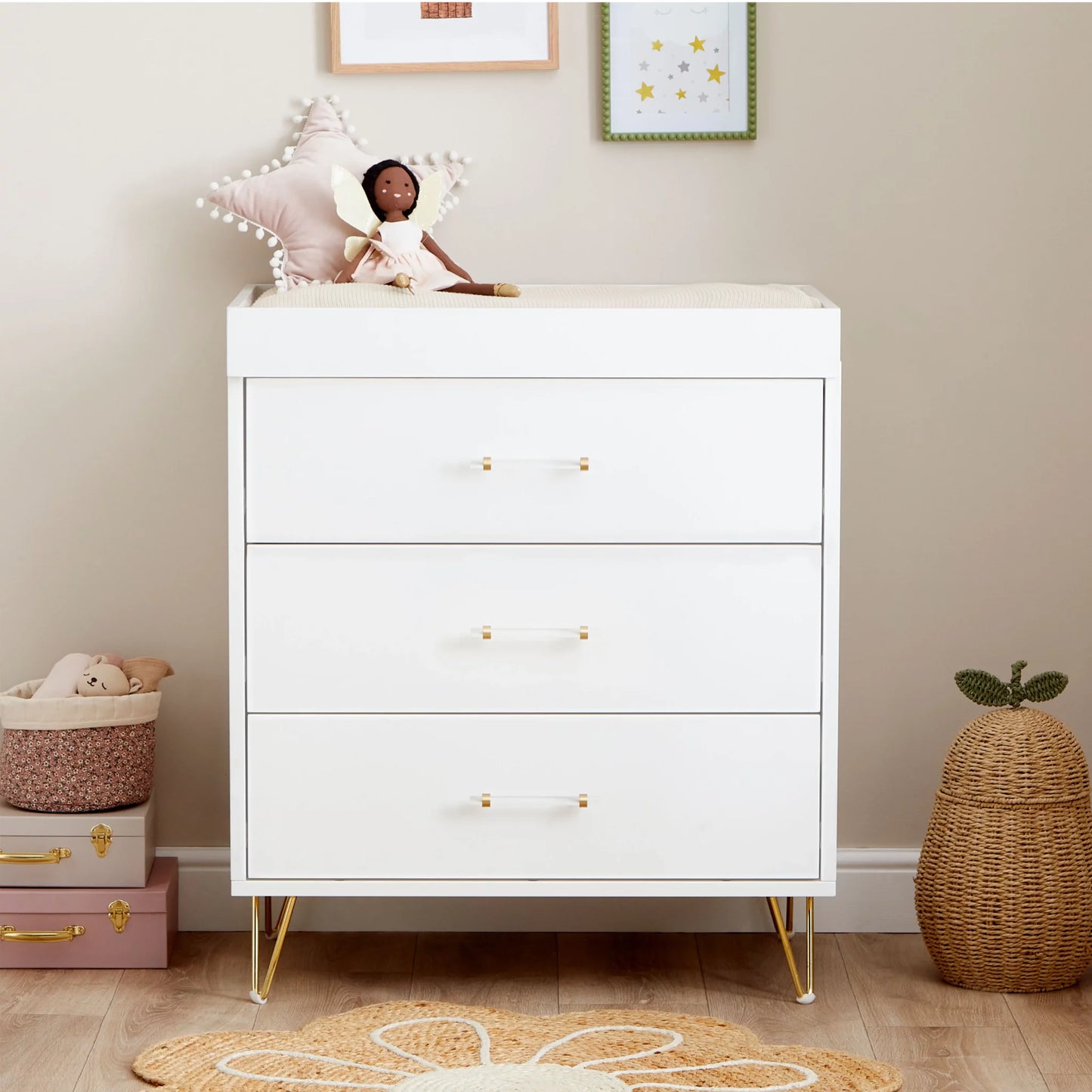 White dresser with gold legs in a room setting with toys and decor.