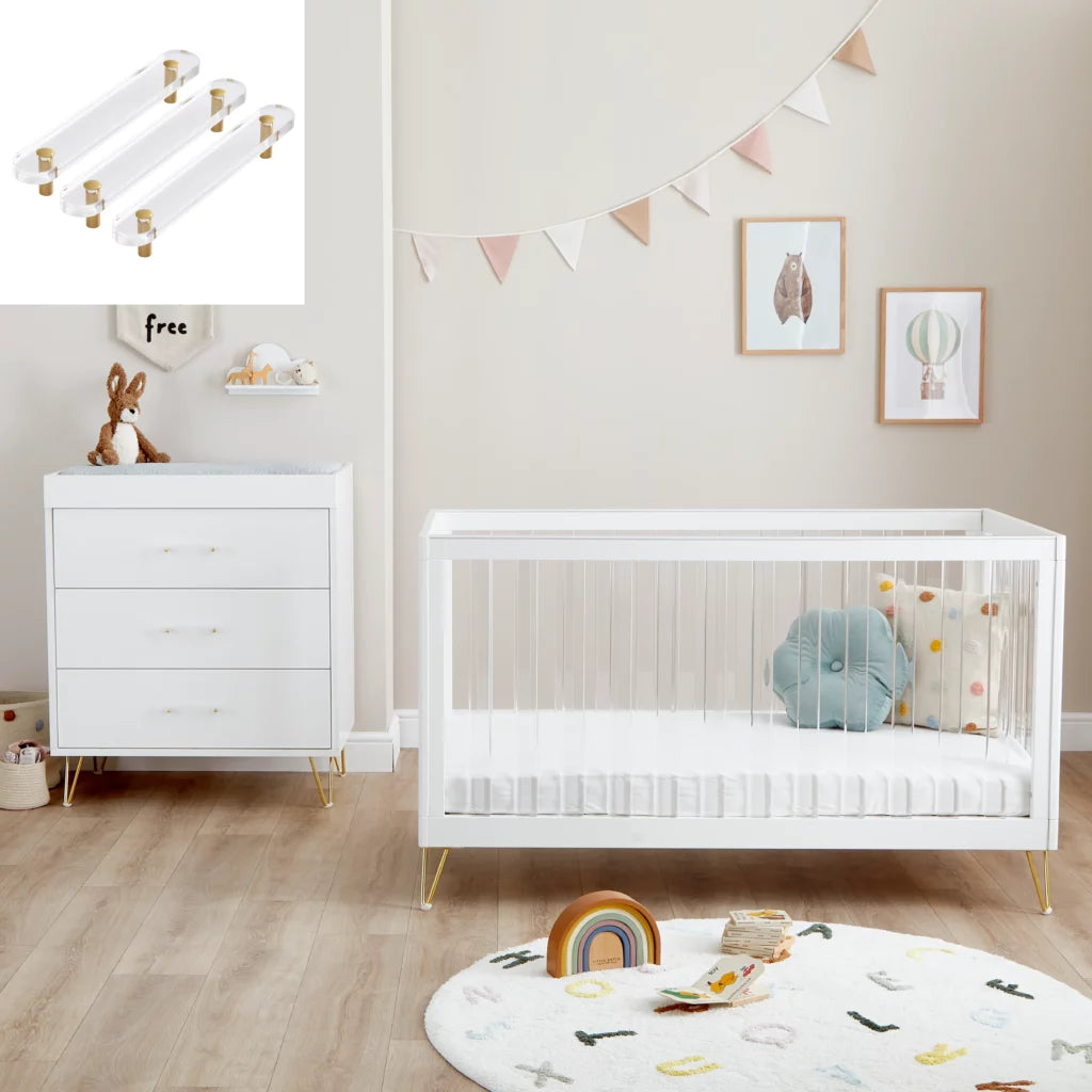 Nursery room with white crib, dresser, and decorative elements.