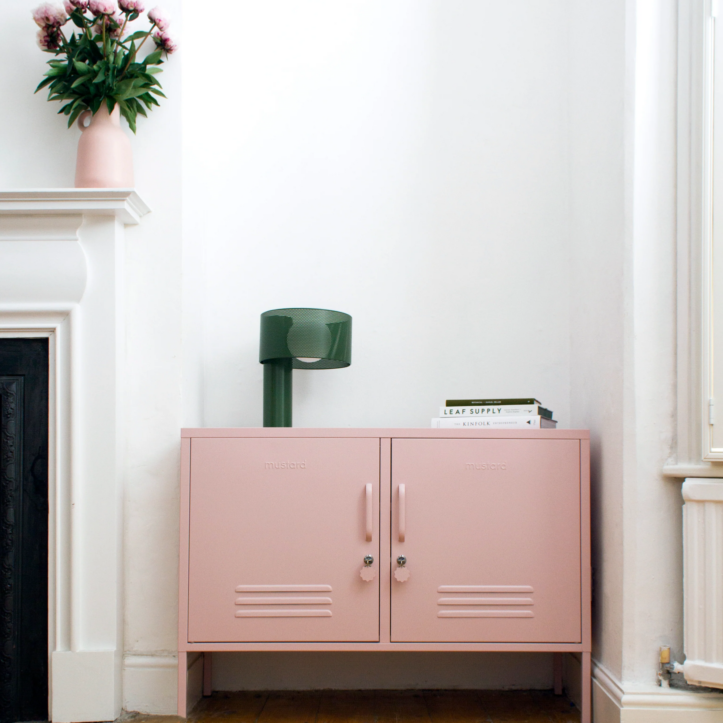 Pink locker with lamp on top with books in an alcove