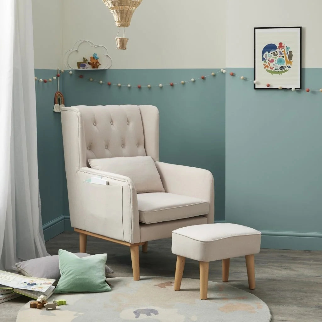 Beige armchair with ottoman in a room with teal walls and decorative elements.