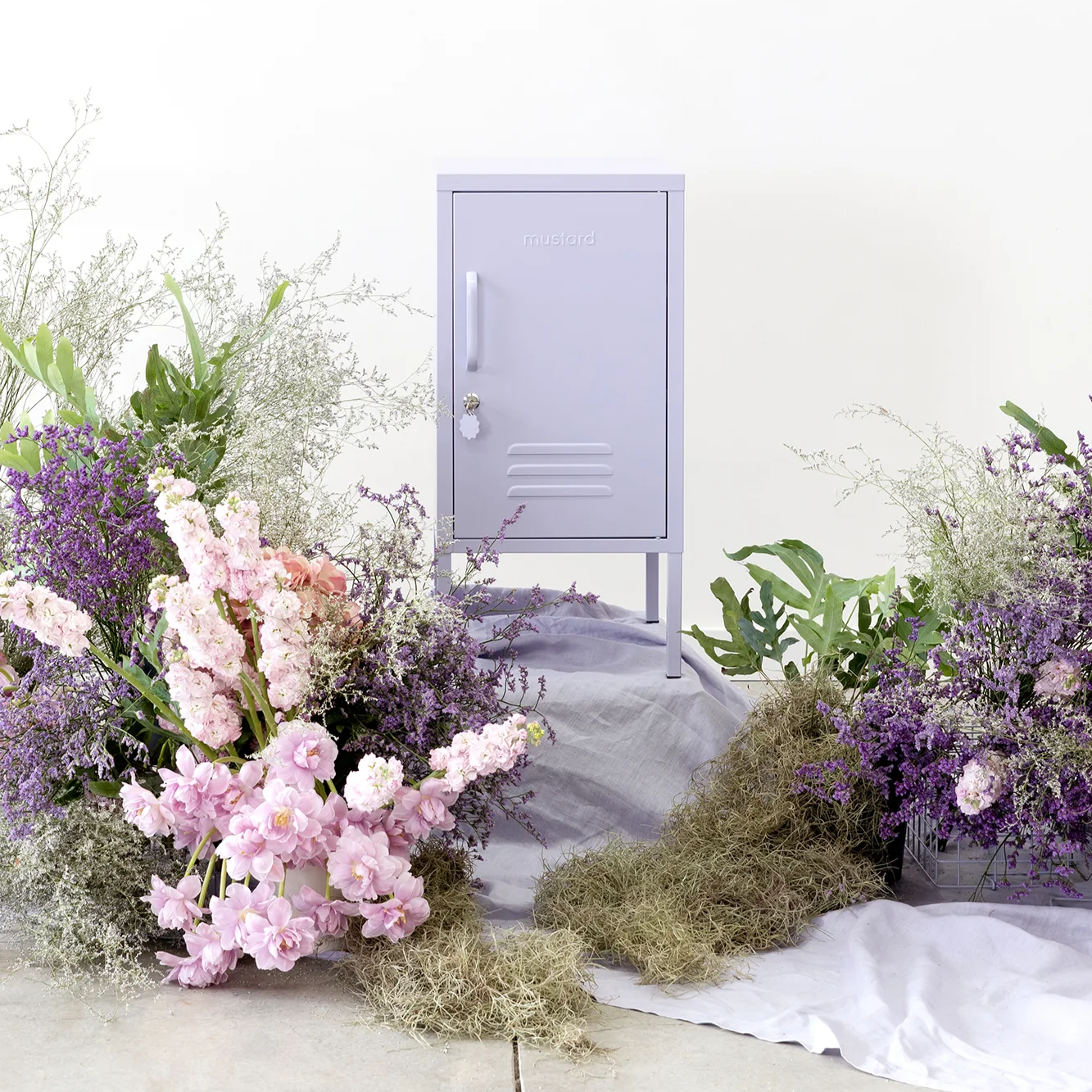 Small purple locker with floral arrangements on a white background