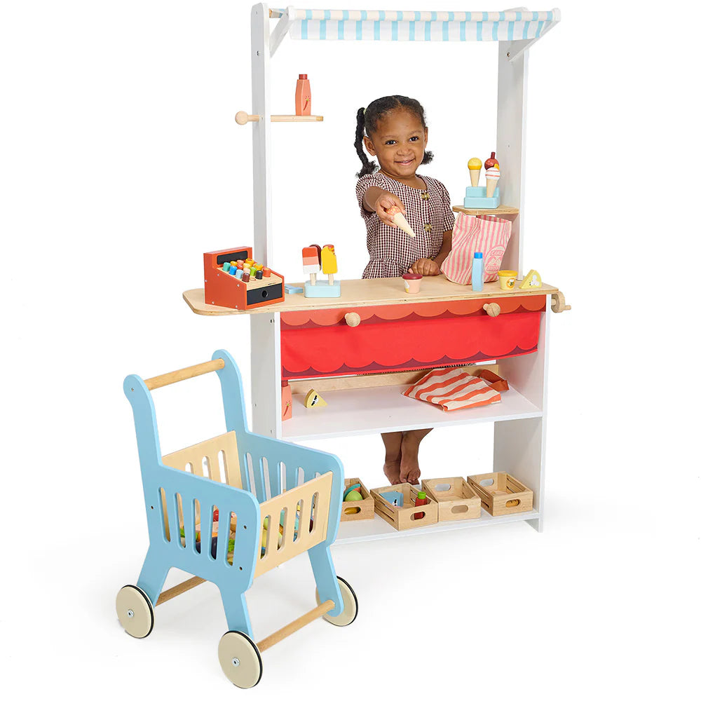 Child playing with a toy kitchen set on a white background