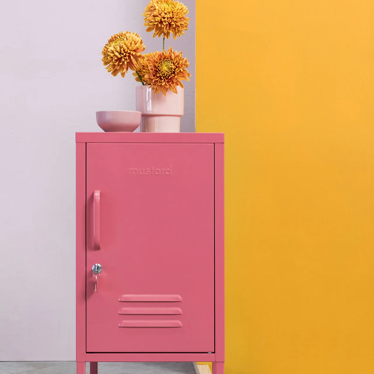 Pink metal locker with flowers against a colorful wall