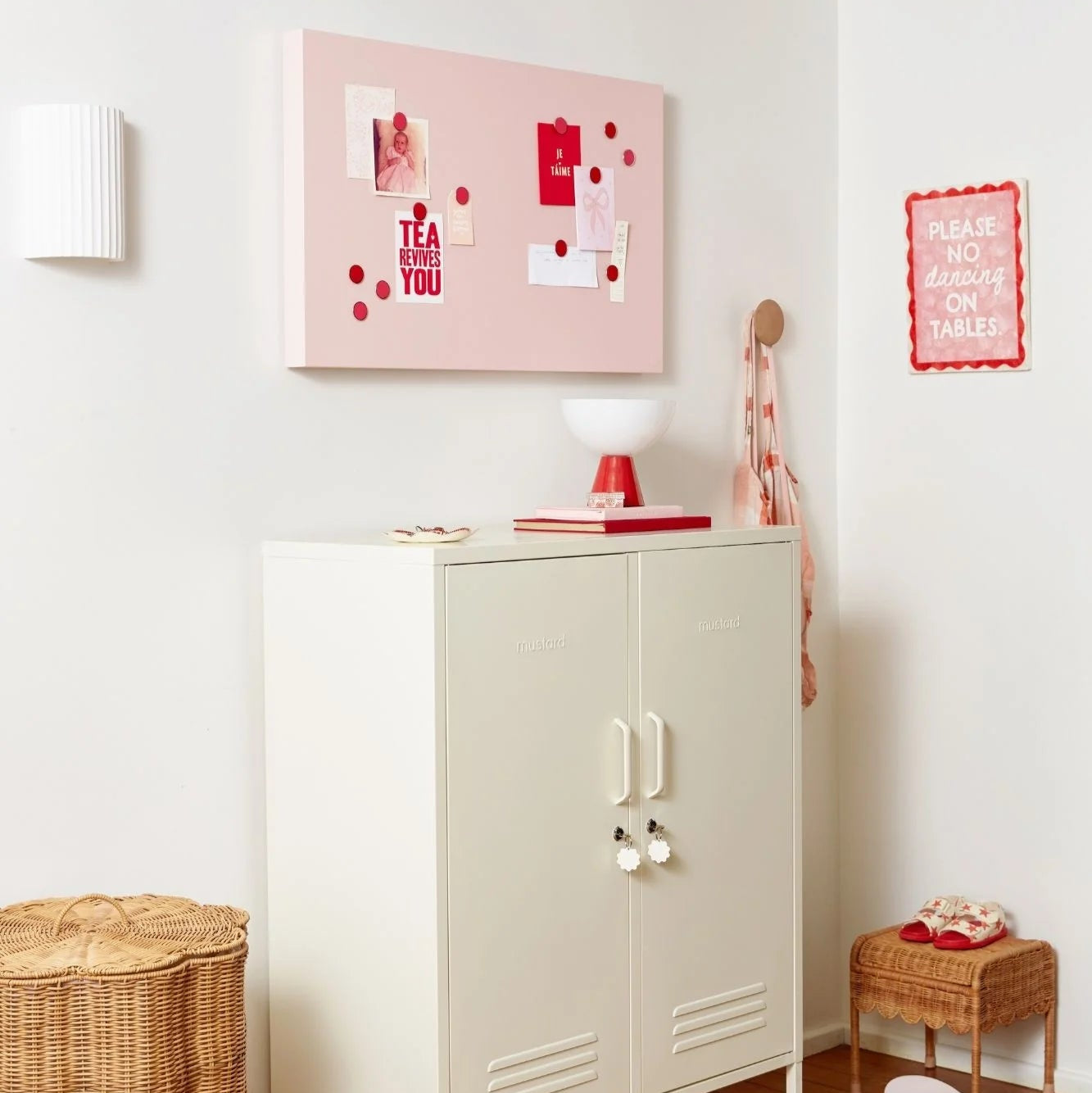 White cabinet with pink decor on a white wall