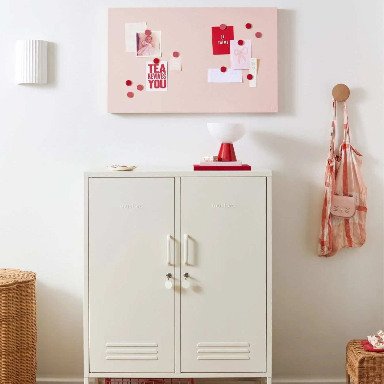 White cabinet with a pinkboard above it in a room setting.