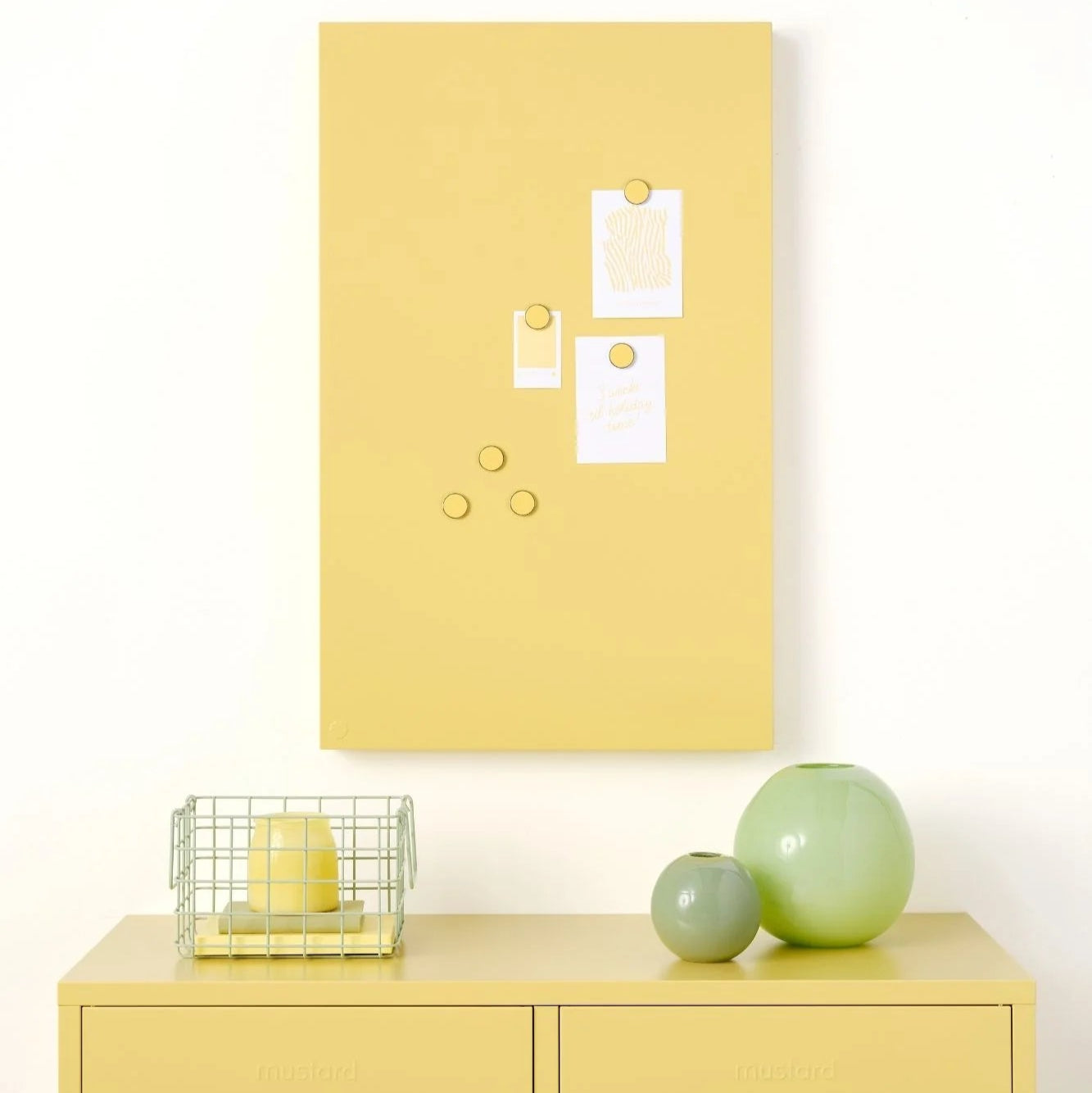 Yellow locker with a whiteboard above it on a white wall.
