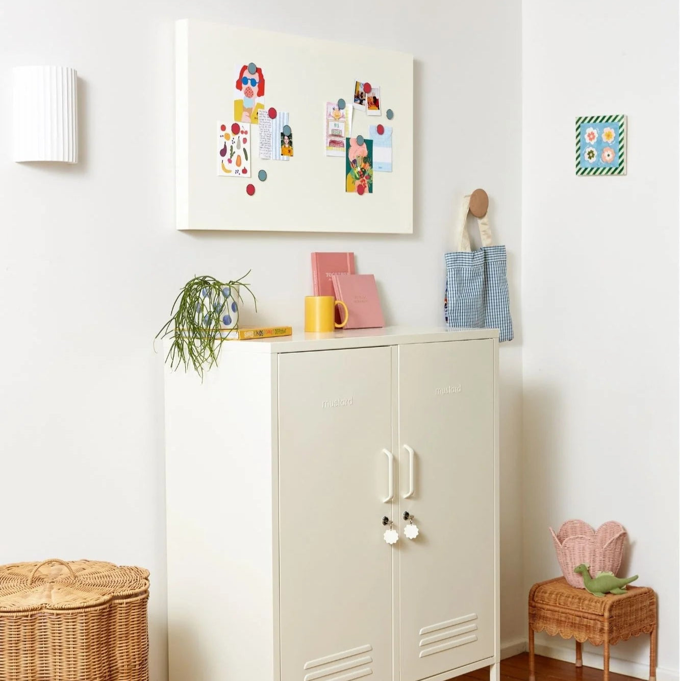 Beige cabinet with decorative items in a room with white walls and wooden flooring.