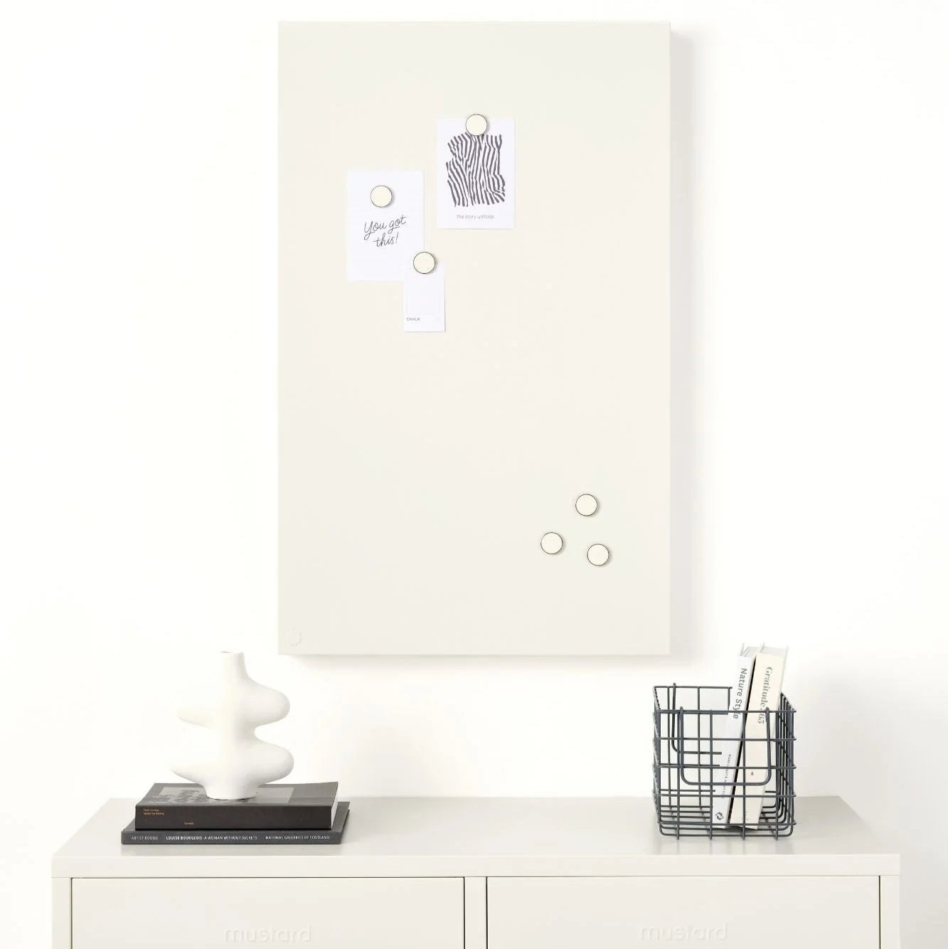 White cabinet with a whiteboard above it on a white wall.