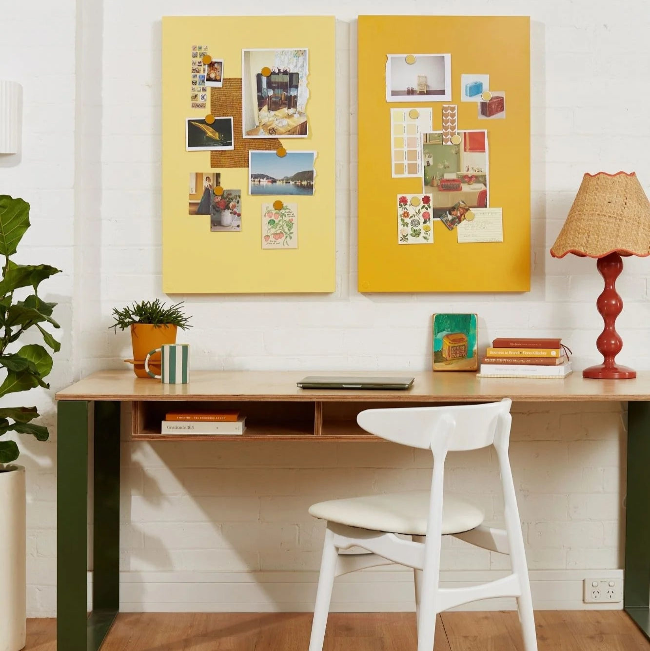 Home office with a desk, chair, and decorative elements on a white wall.