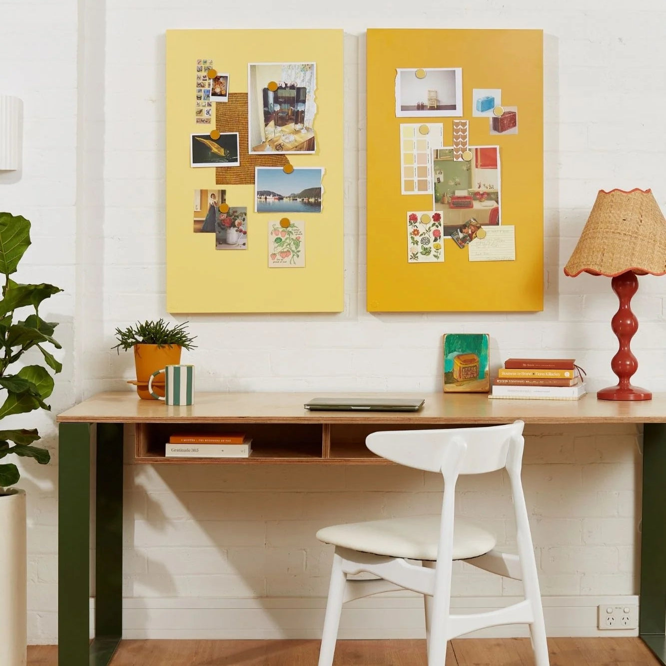 Home office with a desk, chair, and decorative elements on a white wall.