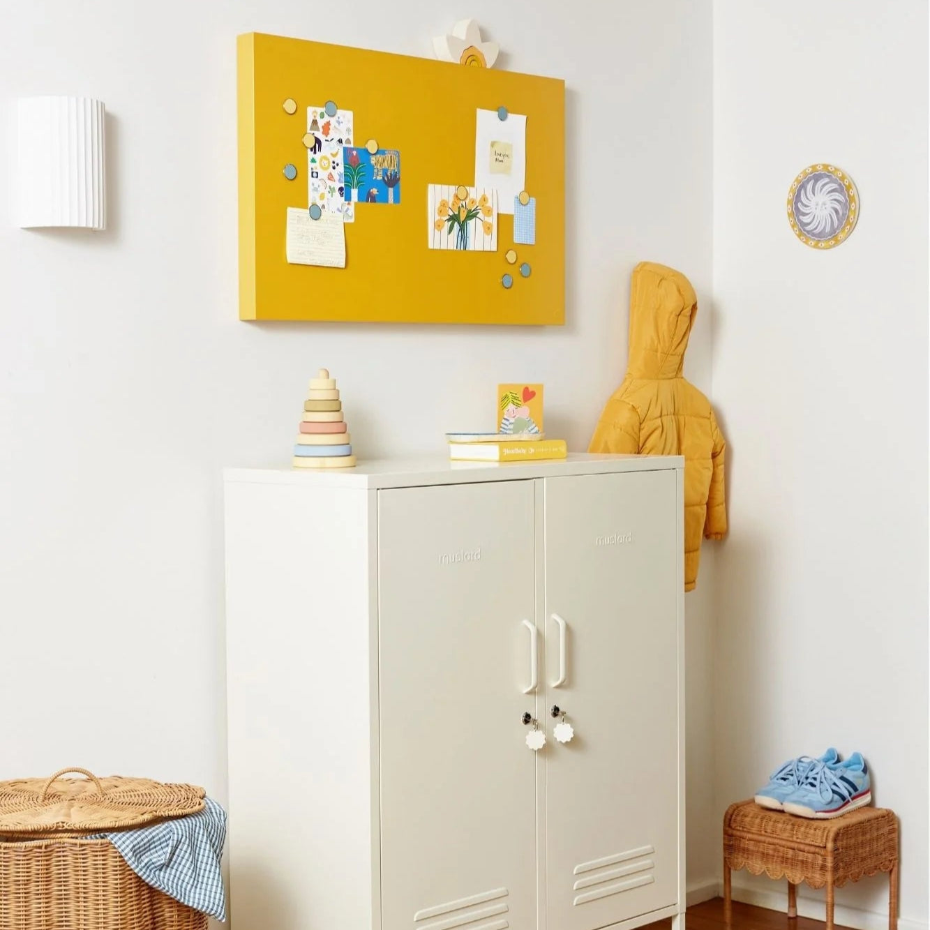 White cabinet with a yellow bulletin board above it in a room setting.