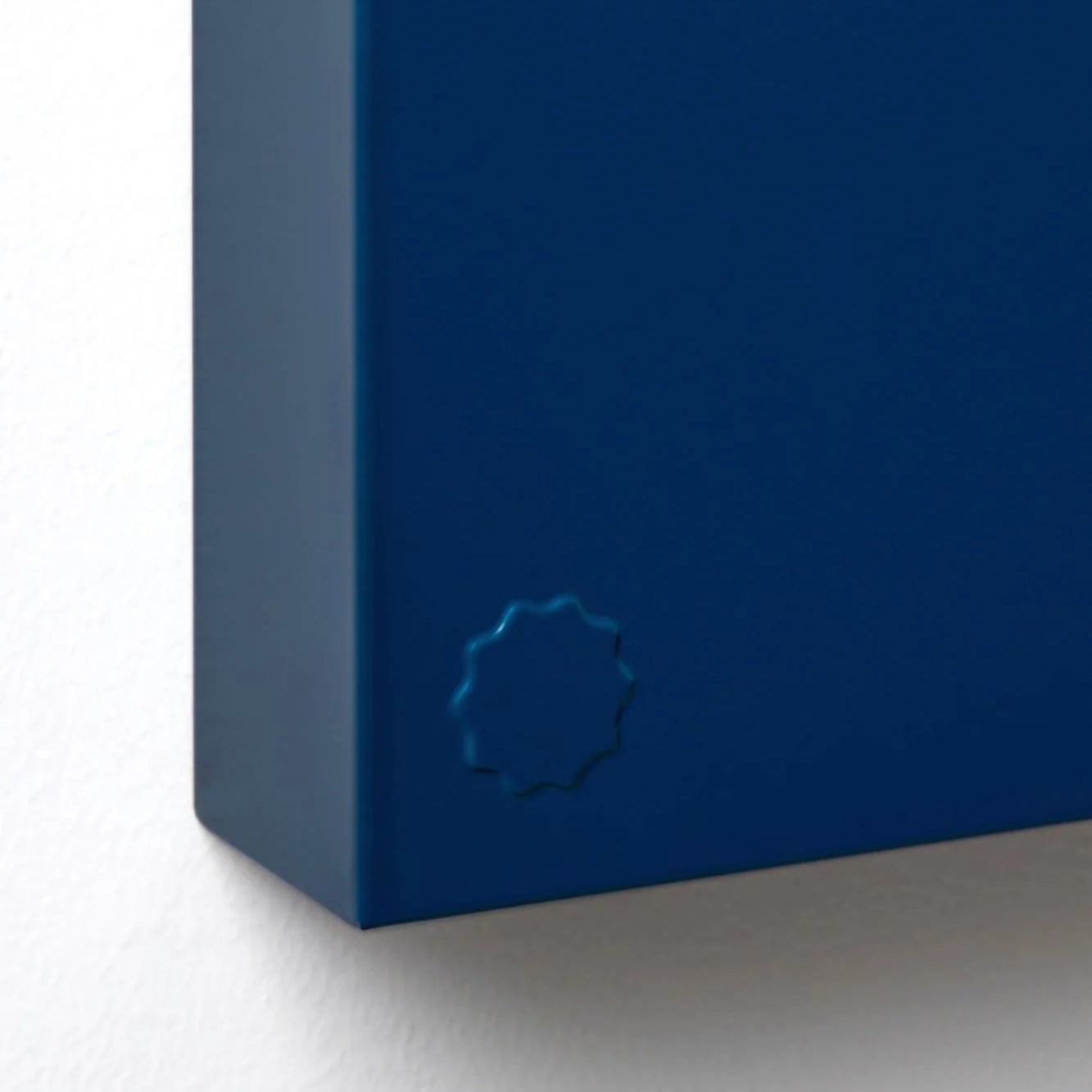 Close-up of a blue notebook with a circular logo on a white background