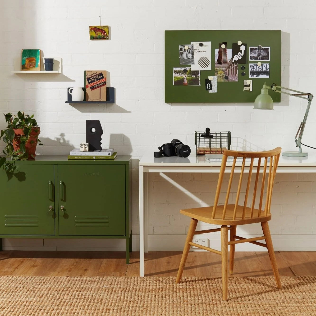 Home office with green cabinet, desk, and wooden chair.
